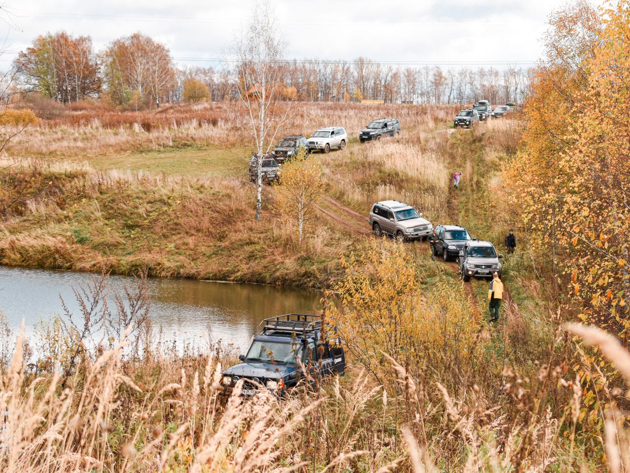 Caravana de camionetas 4x4 en una expedición junto a un lago