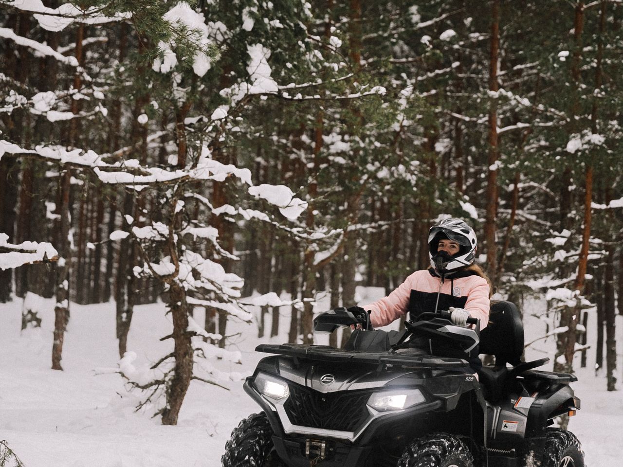 Rider solo en un cuatriciclo ATV por un bosque nevado